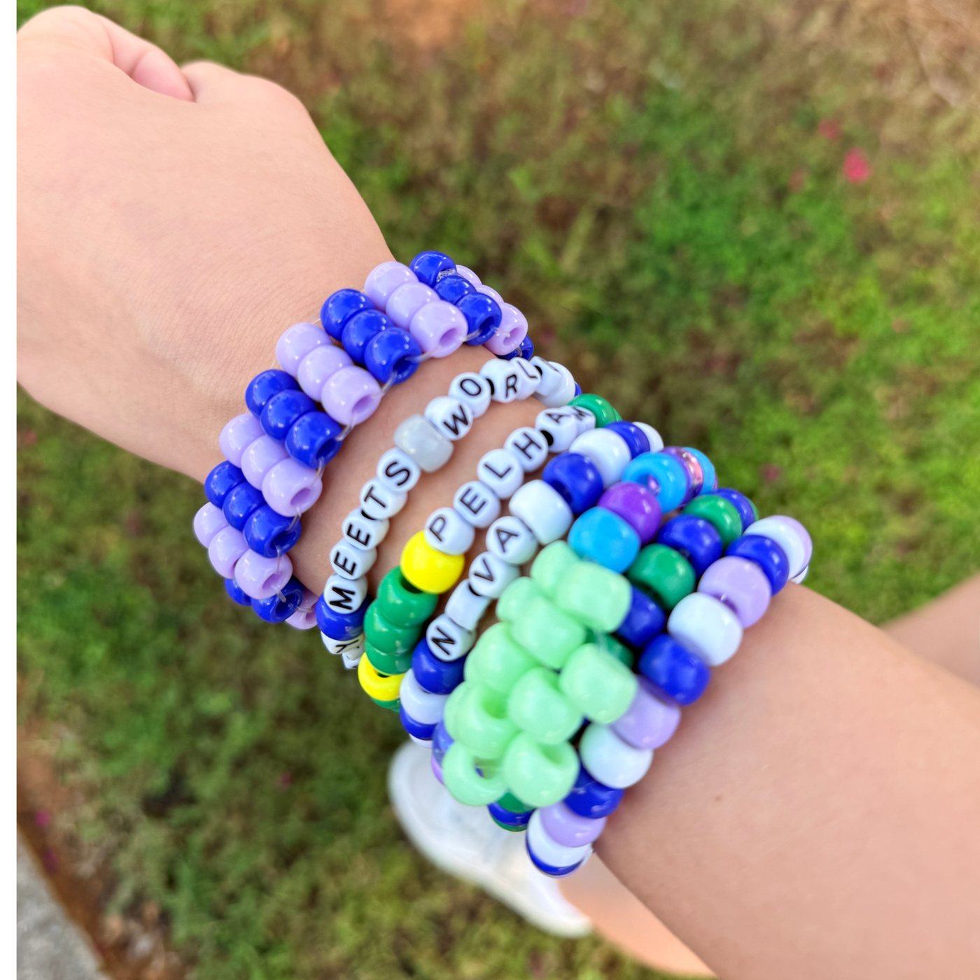 Stack of handmade pony bead bracelets including custom word bracelets spelling names